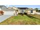 House exterior showcasing a single-story home with a garage and solar panels at 5504 Hamlin Close Rd, Davenport, FL 33896