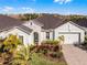 One-story house with a light green exterior, landscaping and paver driveway at 636 Mosaic Blvd, Daytona Beach, FL 32124