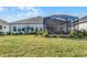 Landscaped backyard with large screened patio at 636 Mosaic Blvd, Daytona Beach, FL 32124