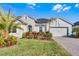 One-story home with light green exterior, landscaping, and paver driveway at 636 Mosaic Blvd, Daytona Beach, FL 32124