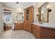 This elegant bathroom features dual vanities, wood cabinetry, and access to other rooms in the home at 661 Cricklewood Ter, Lake Mary, FL 32746