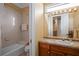 Well-lit bathroom with a neutral-toned tiled shower and a wooden vanity with decorative countertop at 661 Cricklewood Ter, Lake Mary, FL 32746