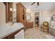 Elegant bathroom featuring dual vanities, custom cabinetry, and access to a spacious walk-in closet at 661 Cricklewood Ter, Lake Mary, FL 32746