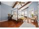 Spacious bedroom with beamed ceilings, a four-poster bed, hardwood floors, and natural light at 661 Cricklewood Ter, Lake Mary, FL 32746