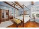 Bedroom boasts beamed ceilings, hardwood floors, four-poster bed, and access to an ensuite bathroom at 661 Cricklewood Ter, Lake Mary, FL 32746
