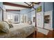 Bedroom view highlights hardwood floors, four-poster bed, beamed ceilings, built in storage, and natural light at 661 Cricklewood Ter, Lake Mary, FL 32746
