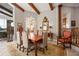 Dining room with beamed ceilings, a chandelier, and views of the home's decorative staircase and outdoor living area at 661 Cricklewood Ter, Lake Mary, FL 32746