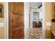 Hallway view showcasing detailed wooden door, decorative flooring, and glimpse into adjacent living space at 661 Cricklewood Ter, Lake Mary, FL 32746