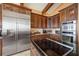 Bright kitchen showcases a stainless steel refrigerator, appliances, wood cabinets and island cooktop at 661 Cricklewood Ter, Lake Mary, FL 32746