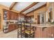 Kitchen with stainless appliances, a breakfast bar, wood cabinets, and beamed ceilings at 661 Cricklewood Ter, Lake Mary, FL 32746
