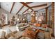 Expansive living room featuring hardwood beams, open layout, and stylish decor leading into the dining area at 661 Cricklewood Ter, Lake Mary, FL 32746