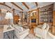 Inviting living room with a large entertainment center, wooden beams, and elegant furnishings at 661 Cricklewood Ter, Lake Mary, FL 32746