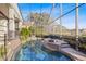 The screened-in pool and spa offers a relaxing outdoor experience with landscaped hedges and water views at 661 Cricklewood Ter, Lake Mary, FL 32746