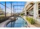 The screened-in pool and spa offers a relaxing outdoor experience with landscaped hedges and water views at 661 Cricklewood Ter, Lake Mary, FL 32746