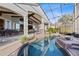 The screened-in pool and spa offers a relaxing outdoor experience with landscaped hedges and water views at 661 Cricklewood Ter, Lake Mary, FL 32746