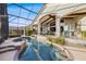 The screened-in pool and spa offers a relaxing outdoor experience with landscaped hedges and water views at 661 Cricklewood Ter, Lake Mary, FL 32746