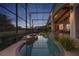 The screened-in pool and spa offers a relaxing outdoor experience with landscaped hedges and water views at 661 Cricklewood Ter, Lake Mary, FL 32746