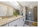 Double vanity bathroom with granite countertop and a glass shower at 7387 Duxbury Ln, Winter Garden, FL 34787