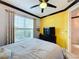 Spacious bedroom with yellow walls, gray bedding, and flat-screen TV at 754 San Joaquin Rd, Kissimmee, FL 34759