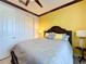 Guest bedroom with yellow walls, gray bedding, and double door closet at 754 San Joaquin Rd, Kissimmee, FL 34759