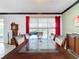 Bright dining room with a glass-top table and dark wood chairs, and red curtains at 754 San Joaquin Rd, Kissimmee, FL 34759