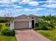 Single-story home with a two-car garage and landscaped yard at 754 San Joaquin Rd, Kissimmee, FL 34759