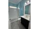 Bathroom with light blue walls, white tub and dark vanity at 984 Maypole Dr, Apopka, FL 32703