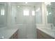 Bathroom with a double sink vanity, bright lights, and a frameless glass shower at 9856 Sharpless Aly, Orlando, FL 32827