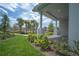 A long front porch with a brick base is landscaped with flowering bushes and palm trees in the background at 9856 Sharpless Aly, Orlando, FL 32827