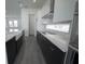 Bright kitchen with stainless steel appliances, black lower cabinets, white countertops, tile backsplash and gray floors at 9856 Sharpless Aly, Orlando, FL 32827