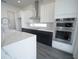 Modern kitchen featuring white cabinets, black lower cabinets, quartz countertops, and stainless steel appliances at 9856 Sharpless Aly, Orlando, FL 32827