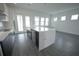 Open kitchen with island, stainless steel appliances, black lower cabinets, and bright living space at 9856 Sharpless Aly, Orlando, FL 32827