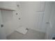 A bright, white laundry room with upper cabinets and tiled floor at 9856 Sharpless Aly, Orlando, FL 32827