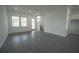 Open-concept living room with gray tile flooring, recessed lighting, large windows, and a staircase at 9856 Sharpless Aly, Orlando, FL 32827