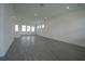 Spacious living room with recessed lighting, gray wood-look floors, and large windows for natural light at 9856 Sharpless Aly, Orlando, FL 32827