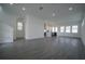 Open-concept living room and kitchen features recessed lighting, gray wood-look floors, and plenty of natural light at 9856 Sharpless Aly, Orlando, FL 32827