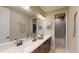 Bathroom with double sinks, wooden cabinets, decorated with cacti and macrame at 987 Ladyfish Trl, St Cloud, FL 34771