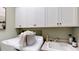 Well-lit laundry area offers extra storage in the overhead cabinets and counter space with a sink at 987 Ladyfish Trl, St Cloud, FL 34771