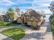 Lakefront property with a large house, landscaping, and circular driveway at 10018 Lone Tree Ln, Orlando, FL 32836