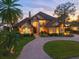 Mediterranean style home with lush landscaping, circular driveway, and waterfront view at 10018 Lone Tree Ln, Orlando, FL 32836