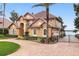 Two-story house with tile roof, landscaping, and a gated driveway leading to lake at 10018 Lone Tree Ln, Orlando, FL 32836