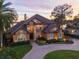 Stunning Mediterranean style home with lush landscaping, circular driveway, and waterfront view at 10018 Lone Tree Ln, Orlando, FL 32836