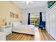 Comfortable bedroom featuring a queen bed, wooden floors, a flat-screen TV, and sliding glass doors to the outside at 103 Rum Run # 103, Davenport, FL 33837