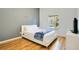 Well-lit bedroom with a queen-size bed, minimalist wall decor, wooden floors, and bright natural light at 103 Rum Run # 103, Davenport, FL 33837