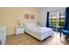 Cozy bedroom with a queen-size bed, wooden floors, and sliding glass door to the outdoor seating area at 103 Rum Run # 103, Davenport, FL 33837