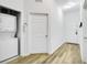 Hallway with in-unit laundry, white doors, and wood-look floors at 103 Rum Run # 103, Davenport, FL 33837