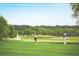 People playing golf on a lush green course with a water fountain in the background at 10300 Winter Sparkle Cir, Golden Oak, FL 32836
