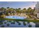Stunning pool area with palm trees, lounge chairs, and the building reflected in the water at 10300 Winter Sparkle Cir, Golden Oak, FL 32836