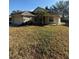 Tan house with a two-car garage and large yard at 10418 Reagans Run Dr, Clermont, FL 34711