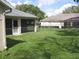 Backyard area featuring lush green grass and a view of two screened-in patios at 11618 Grand Bay Blvd, Clermont, FL 34711